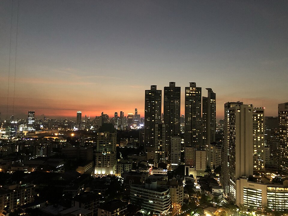 Panorama Bangkoku, tętniącej życiem stolicy Tajlandii, ukazująca nowoczesne wieżowce i tradycyjne świątynie w harmonijnym współistnieniu.