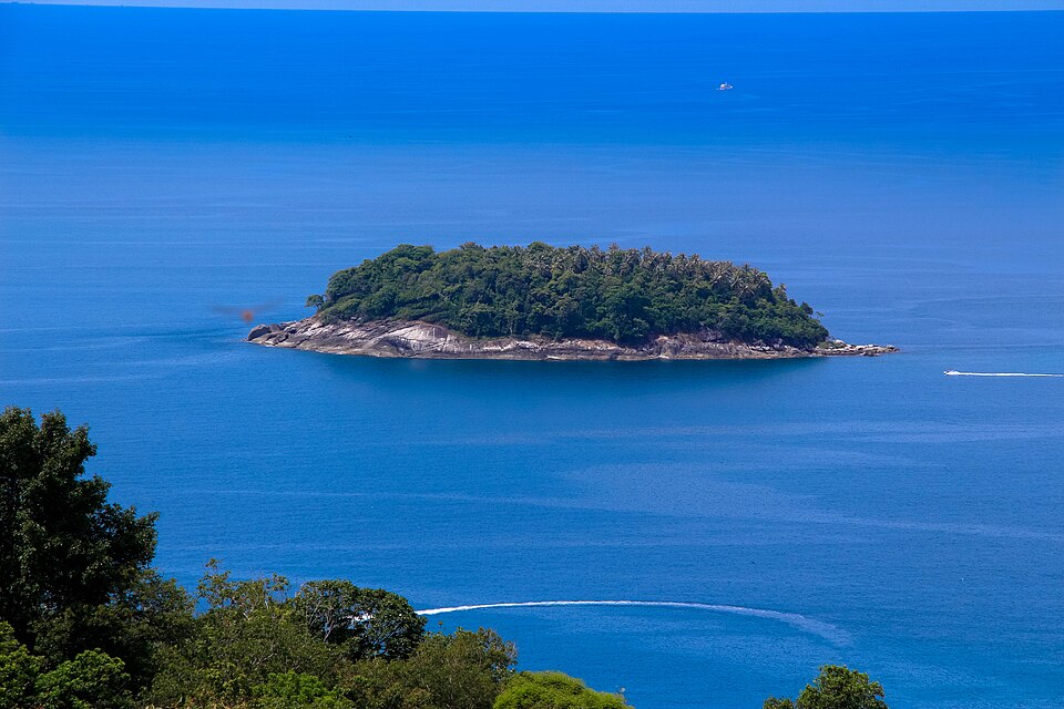 Plaża na wyspie Phuket w Tajlandii zachwyca turystów białym piaskiem i turkusową wodą, stanowiąc idealne miejsce na relaks i zwiedzanie.